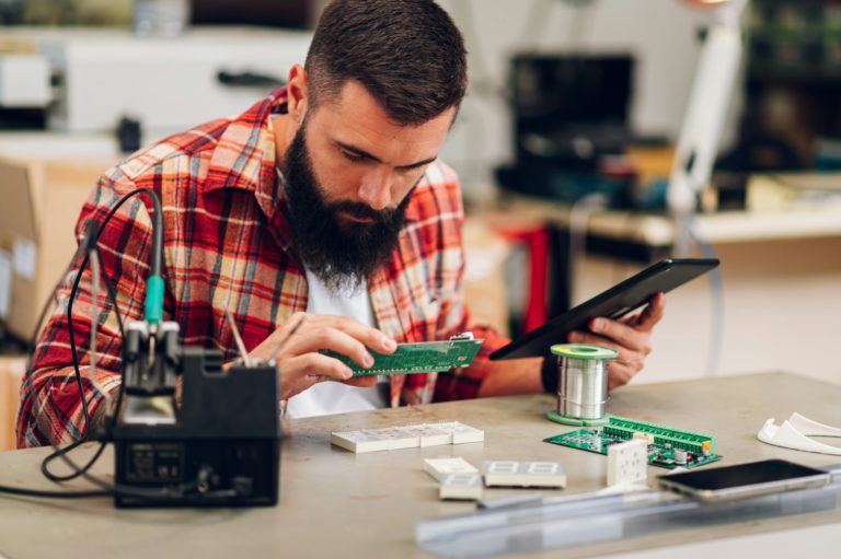 Technicien Teclab travaillant avec une tablette dans un atelier de réparation informatique sur Craponne (69290)